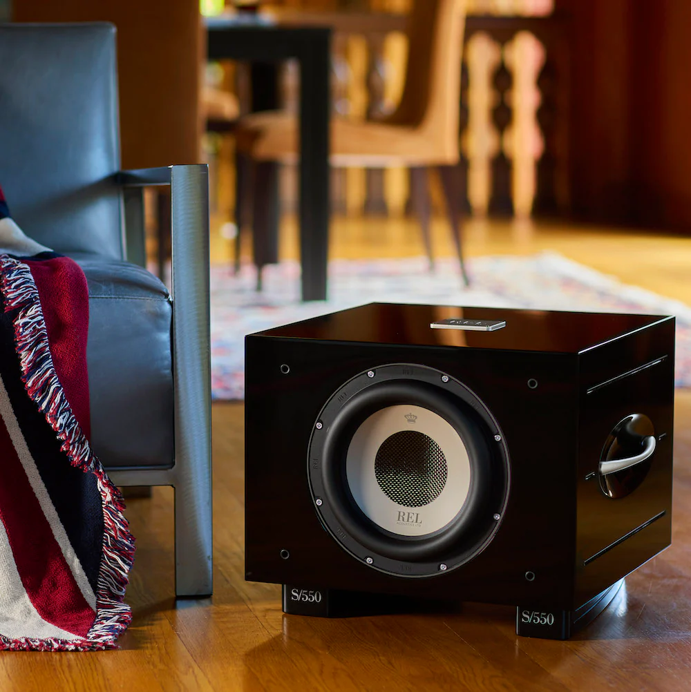 Official REL REL S/550 shown in a styled room setting.